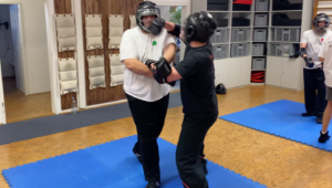 Schüler beim kontrollierten Sparring mit Schutzausrüstung