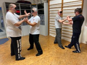 Wing Chun Schüler trainieren Chi-Sao mit Augenmaske – Schulung von taktilem Gefühl, Wahrnehmung und Reflexen ohne visuelle Kontrolle.